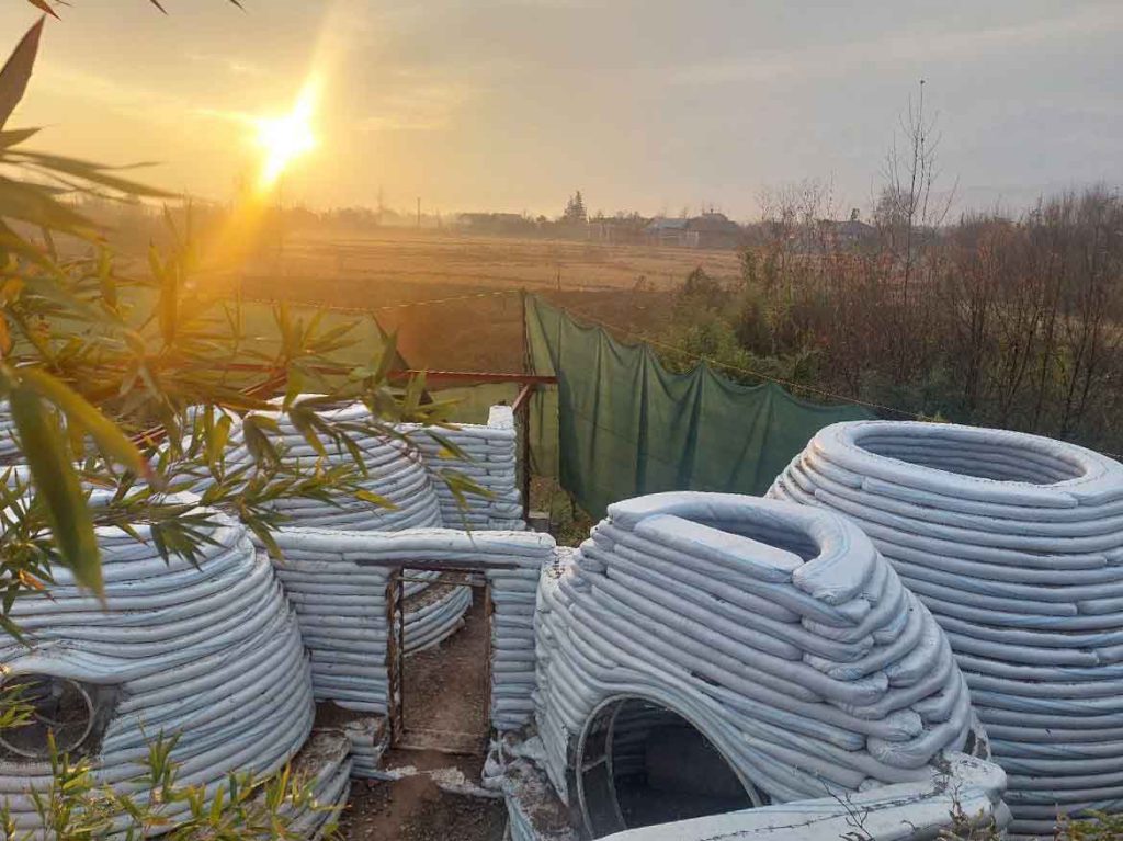 an unfinished superadobe with the view of sunrise